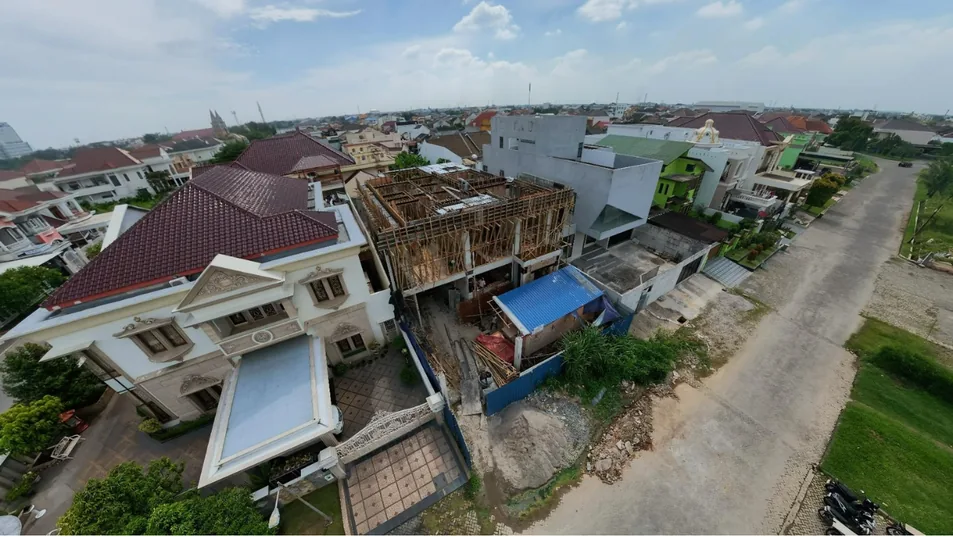Progres pembangunan rumah SH House dari seberang jalan, struktur dan perancah masih terlihat.